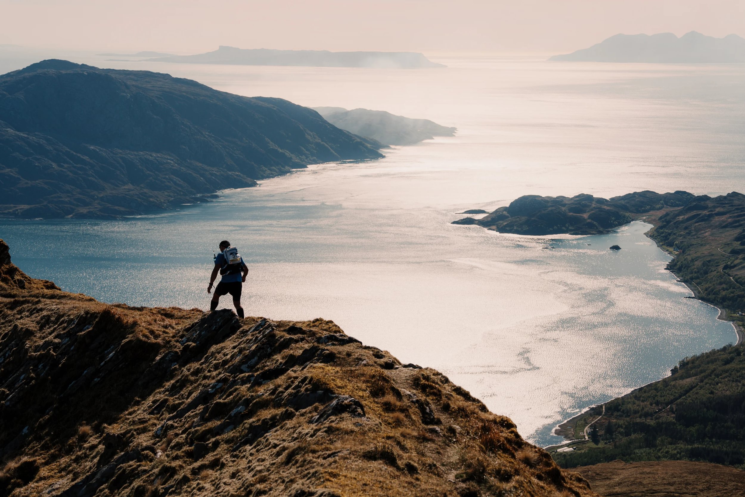 A runner on a ridgeline above a Highland sea loch, BTU Highland Ultra